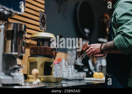 Der Barista bereitet köstliche heiße Schokolade in einem gemütlichen Café zu Stockfoto