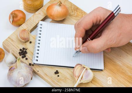 Notebook für kulinarische Notizen auf einem Schneidebrett Stockfoto