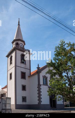 Weiße Fassade der Kirche, die unserer Lieben Frau von der makellosen Empfängnis gewidmet ist. Blauer Himmel mit weißen Wolken. Porto Moniz, Madeira, Portugal. Stockfoto
