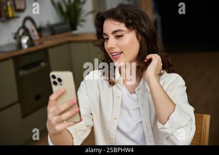 In einem lebhaften Gespräch genießt eine junge Frau einen fröhlichen Moment zu Hause. Stockfoto