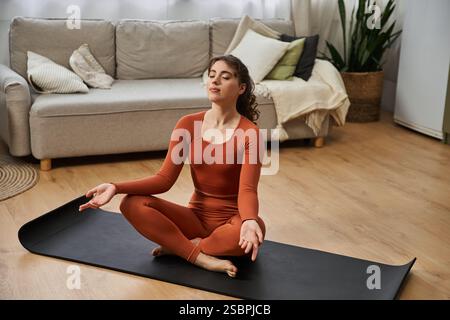Eine junge Frau genießt eine meditative Yoga-Sitzung in ihrem Komfort zu Hause, in der Ruhe. Stockfoto