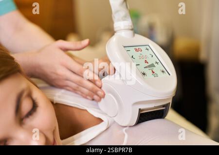 Ein erfahrener Fachmann führt eine Dermatologie-Behandlung an einer jungen Frau in einer ruhigen Klinik durch. Stockfoto