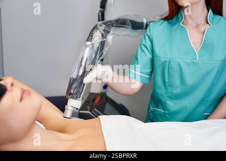 Eine junge Frau, die in einer modernen Klinik eine sichere, effektive Laserhaarentfernung bekommt. Stockfoto