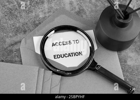 Eine Lupe zeigt den Zugang zu Bildung auf einem Papier mit Umschlägen und einer Vase und spiegelt so eine kreative Art des Lernens wider. Stockfoto