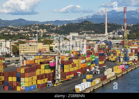 Hochwinkelansicht der Reihen von gestapelten rechteckigen Transportbehältern aus Metall und Portalkränen am Dock im Hafen von La Spezia, Italien, Europa Stockfoto