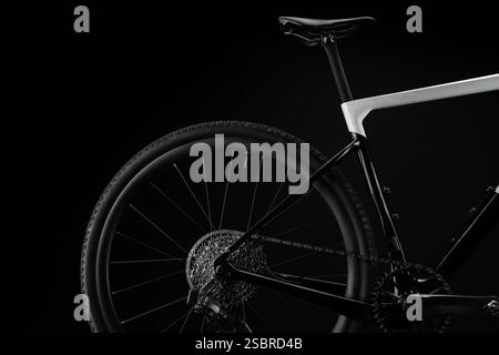 Nahaufnahme des Studioaufnahmen des hinteren Abschnitts des Gravel-Bikes mit Kassette, Schalthebel, Kette, Kurbelgarnitur, und sattelt in scharfen Details auf schwarzem Hintergrund. Stockfoto