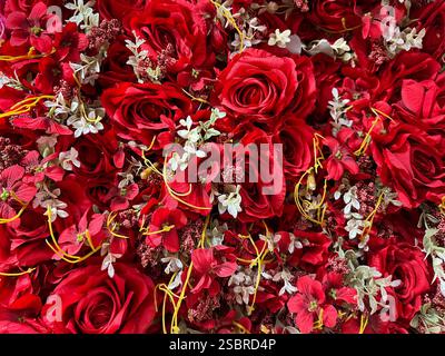 Wunderschöne Rosenblumen-Anordnung in tiefroter Farbe. Rote Rosen Blumenstrauß, mit Blättern und Babyatmen, die eine romantische und schöne Dekoration bilden Stockfoto