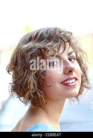 Porträt einer schönen jungen Frau lächelnd im Freien Stockfoto