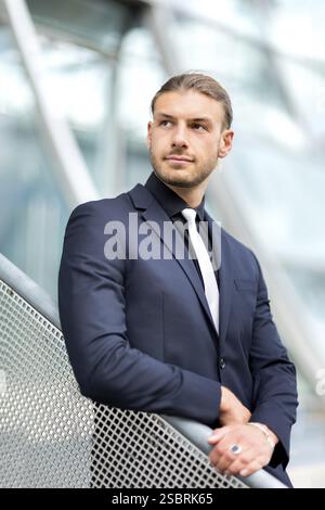 Hübscher, stilvoller junger Geschäftsmann, der im Freien ein Porträt posiert Stockfoto