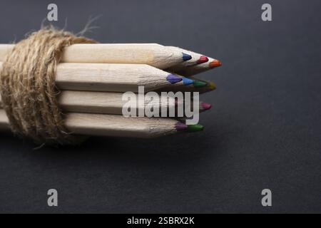 Bündel von Buntstiften mit Schnur auf schwarz gewickelt Stockfoto