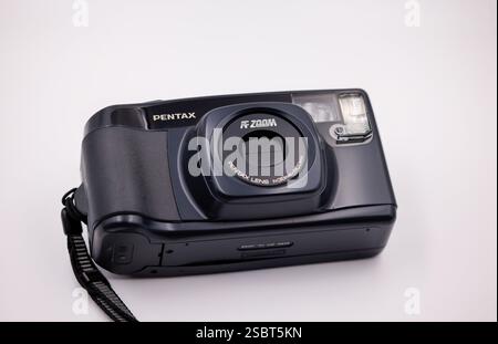Pentax Retro-Kompaktkamera für Filmfotos auf weißem Hintergrund. Vorderansicht der integrierten geschlossenen Linse und des Blitzes Stockfoto