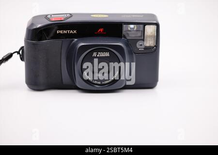 Pentax Retro-Kompaktkamera für Filmfotos auf weißem Hintergrund. Vorderansicht der integrierten geschlossenen Linse und des Blitzes Stockfoto
