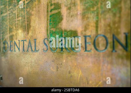 Nahaufnahme einer Messingmetallplakette für einen Zahnarzt. UK Stockfoto