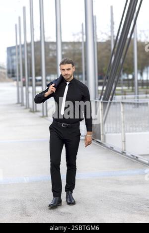 Hübscher, stilvoller junger Geschäftsmann, der im Freien ein Porträt posiert Stockfoto