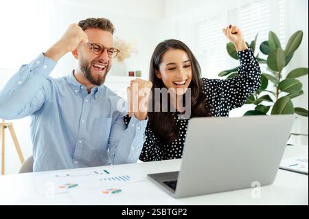 Zielerreichung, gute Arbeit. Fröhliches Geschäftsteam feiert Erfolg, multirassische Männer und Frauen, die mit Begeisterung Fäuste machen, Diagramme analysieren und Ziele erreichen, symbolisieren Erfolg und Zusammenarbeit Stockfoto
