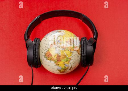 Headset auf Globus isoliert auf dem roten Stockfoto