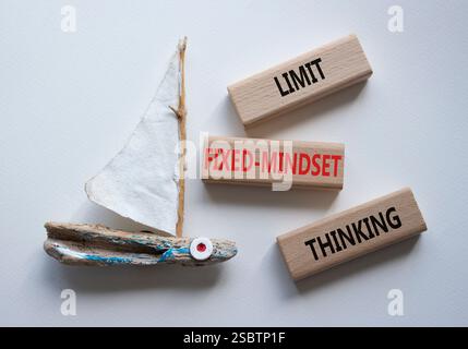 Begrenzen Sie das Denksymbol für feste Denkweisen. Konzeptworte beschränken das Denken auf Holzblöcke. Schöner weißer Hintergrund mit Boot. Business Conce Stockfoto