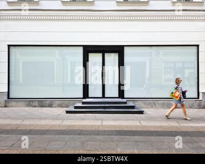 Eine moderne Ladenfront mit matten Fenstern und einer schwarzen Tür bietet einen sauberen Hintergrund für Mockups, Anzeigen und Branding. Stockfoto