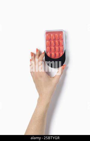 Frauenhand mit falschen Nägeln nach Nagelstudio auf weißem Hintergrund. Falsche oder falsche Nägel mit Beschneidungspfad. Kunstnageldesign an den Fingern. Stockfoto