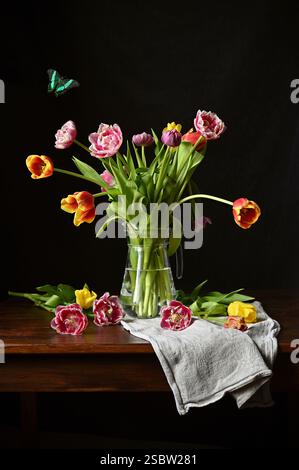 Foto von Stillleben im niederländischen Stil mit bunten Tulpen und einem Schmetterling Stockfoto