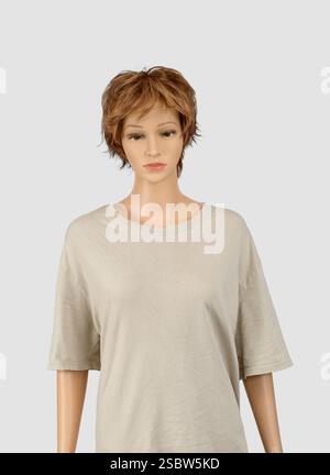 Vertikale Aufnahme einer weiblichen Schaufensterpuppe in einem leeren T-Shirt auf hellgrauem Hintergrund. Stockfoto