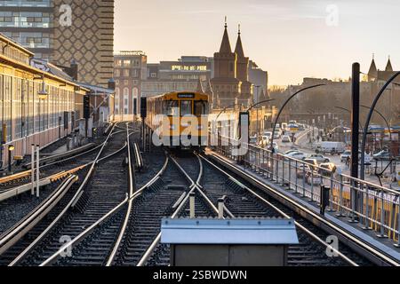 Eine U-Bahn am Bahnhof Warschauer Straße. Hier verkehren U-Bahnen der Linie U1 und U3. Im Hintergrund die Türme der Oberbaumbrücke über die Spree. *** U-Bahn am Bahnhof Warschauer Straße U-Bahn-Züge der Linien U1 und U3 fahren hier die Türme der Oberbaumbrücke über die Spree im Hintergrund Stockfoto
