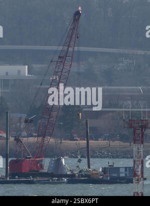 Parts of a plane are lifted from the water near the wreckage site in ...
