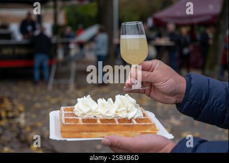 Weinfest in Schengen, Luxemburg, französischen oder luxemburgischen Waffeln mit Schlagsahne und einem Glas Jungwein, der im Herbst im Freien gegessen wird Stockfoto