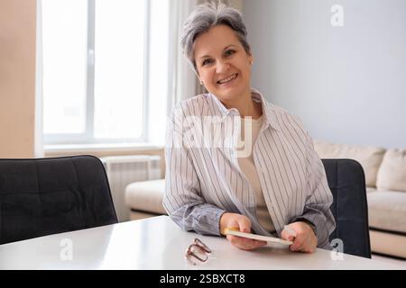 Porträt einer schönen, gepflegten Rentnerin im Alter. Ältere Dame mit grauem Haar sitzt Stockfoto