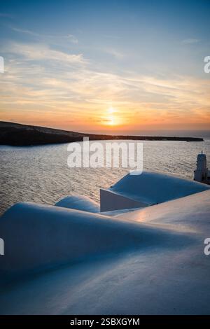 Weiße Kuppeldächer von Häusern in Oia leuchten gegen das Licht des Sonnenuntergangs, Santorin, Griechenland Stockfoto