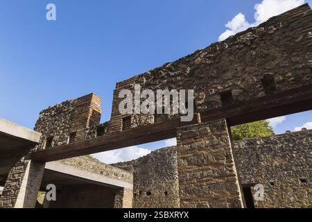 Alte Deckenmauern aus Stein und Ziegelmauern mit Öffnungen, die von Terrakotta-Ziegeln und farbigen Steinsäulen an den antiken Ruinen von Pomp unterstützt werden Stockfoto