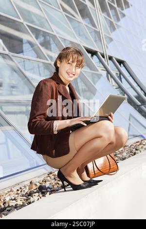Junge Geschäftsfrau sitzt auf der Treppe, mit Laptop-computer Stockfoto