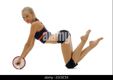 Wunderschöne Blondine in einem Sportoutfit. Sie macht Gymnastikübungen Stockfoto