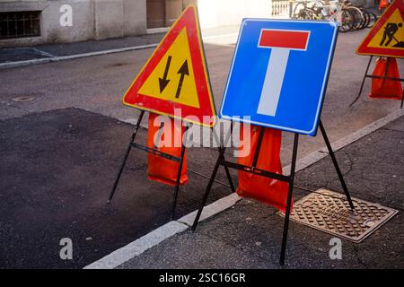 Cremona, Italien - 30. Januar 2025 zwei vorübergehende Verkehrsschilder stehen auf einer Stadtstraße, die Fahrer vor bevorstehenden Straßenarbeiten und einer gesperrten Fahrbahn warnen. Oder Stockfoto