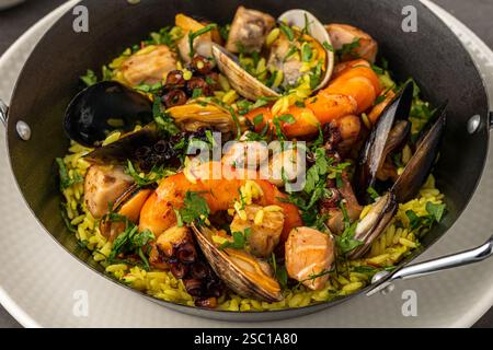 Blick von oben auf traditionelle spanische Meeresfrüchte-Paella mit Reis, Muscheln und Garnelen in einer Pfanne auf Steintisch Stockfoto