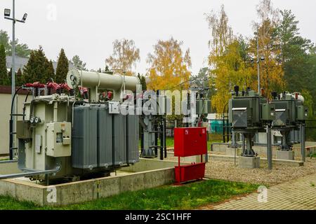 Stromverteilungstransformatoren in einer elektrischen Unterstation im Freien, hermetisch abgedichteter dreiphasiger Wellrippen-Öltransformator Stockfoto