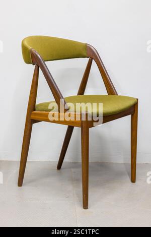 Stilvoller moderner Sessel aus der Mitte des Jahrhunderts. Retro-Design mit olivgrüner Polsterung und warmem Holzrahmen. Perfekt für Ihre Innenarchitektur. Stockfoto