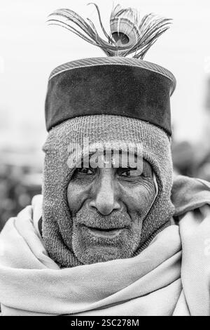 13. Januar 2025, Prayagraj, uttar Pradesh, Indien. Ein alter Mann in Kumbh Mela, der einen Hut mit einer Pfauenfeder trägt und Weisheit und Hingabe ausstrahlt. Stockfoto