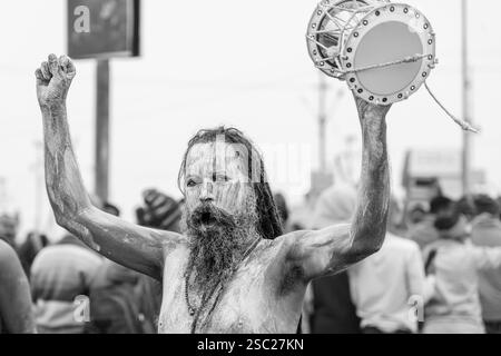 14. Januar 2025, Prayagraj, uttar Pradesh, Indien. Ein Naga Sadhu, frisch gebadet im heiligen Sangam-Wasser, hält einen Damroo in der Hand, seine Anwesenheit radi Stockfoto