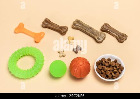 Trockenfutter und spielerisches Spielzeug für Hunde. Granuliertes Tierfutter in einer Schüssel und künstliches Hundekauen Knochenfutter mit Vitaminen. Bälle, ein Kaugummi-Kauknochen und Stockfoto