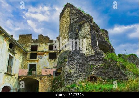Die Ruinen der Burg Picinisco mit den verlassenen Häusern, die sich vor dem Hintergrund des blauen Himmels und der weißen Wolken an die Mauern lehnen. Picinisco, Latium Stockfoto