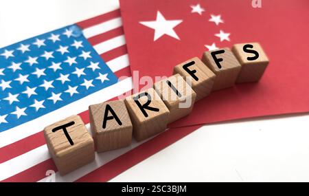 Words Trade war aus Holzwürfeln, amerikanische und chinesische Flaggen mit Münzen auf grauem Tisch Stockfoto