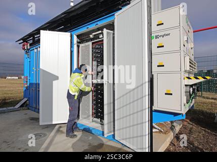Wernigerode, Deutschland. Februar 2025. Bauleiter Malte Klebe öffnet den Schrank eines Batteriespeichersystems der EDF Renewables Deutschland GmbH. Das 2024 installierte Batteriespeichersystem wird in Zusammenarbeit mit der Hasseröder Brauerei GmbH betrieben. Quelle: Matthias Bein/dpa/Alamy Live News Stockfoto
