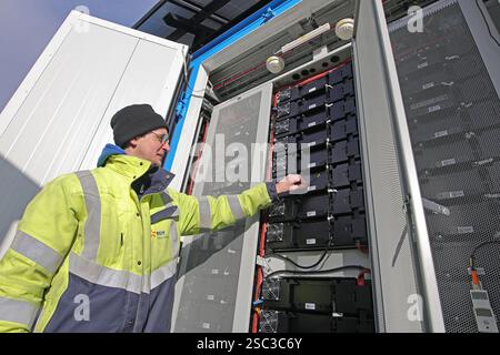 Wernigerode, Deutschland. Februar 2025. Bauleiter Malte Klebe öffnet den Schrank eines Batteriespeichersystems der EDF Renewables Deutschland GmbH. Das 2024 installierte Batteriespeichersystem wird in Zusammenarbeit mit der Hasseröder Brauerei GmbH betrieben. Quelle: Matthias Bein/dpa/Alamy Live News Stockfoto