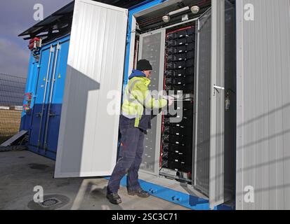 Wernigerode, Deutschland. Februar 2025. Bauleiter Malte Klebe öffnet den Schrank eines Batteriespeichersystems der EDF Renewables Deutschland GmbH. Das 2024 installierte Batteriespeichersystem wird in Zusammenarbeit mit der Hasseröder Brauerei GmbH betrieben. Quelle: Matthias Bein/dpa/Alamy Live News Stockfoto