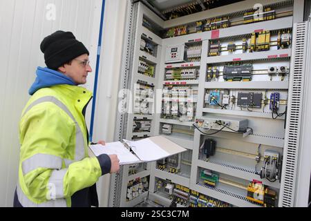 Wernigerode, Deutschland. Februar 2025. Bauleiter Malte Klebe öffnet den Schrank eines Batteriespeichersystems der EDF Renewables Deutschland GmbH. Das 2024 installierte Batteriespeichersystem wird in Zusammenarbeit mit der Hasseröder Brauerei GmbH betrieben. Quelle: Matthias Bein/dpa/Alamy Live News Stockfoto