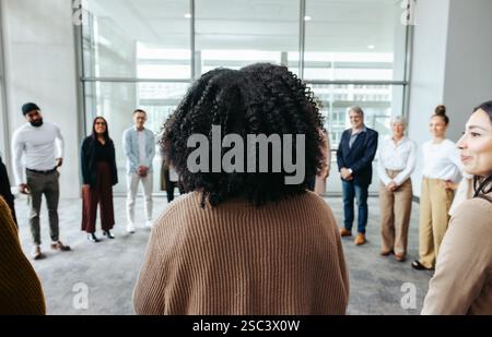 Geschäftsfrau, die eine Konferenz mit Kollegen leitet und in einem modernen Büroumfeld professionell diskutiert. Stockfoto