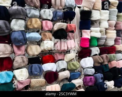 Kiew, Ukraine - 04. Februar 2025: Verschiedene gestrickte Wintermützen und Mützen werden auf einem Markt zum Verkauf angeboten Stockfoto