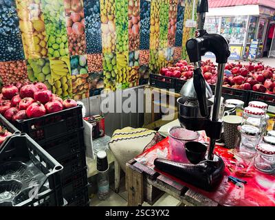Kiew, Ukraine - 4. Februar 2025: Farbenfroher Marktstand mit Granatäpfeln, Saftabsauger und Obstposter Stockfoto