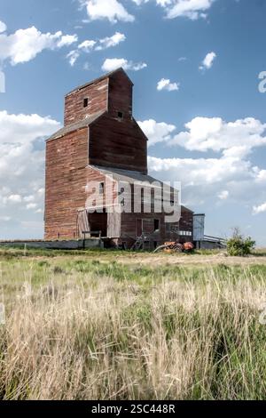 Ein rotes Getreidesilo ist auf einem Feld. Das Silo ist leer. Das Silo ist alt und hat viel Rost Stockfoto